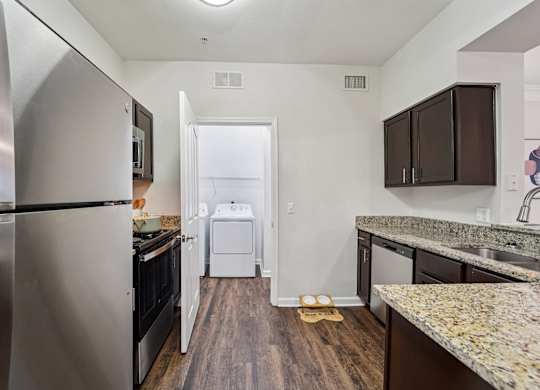 A kitchen with a refrigerator, oven, and dishwasher.