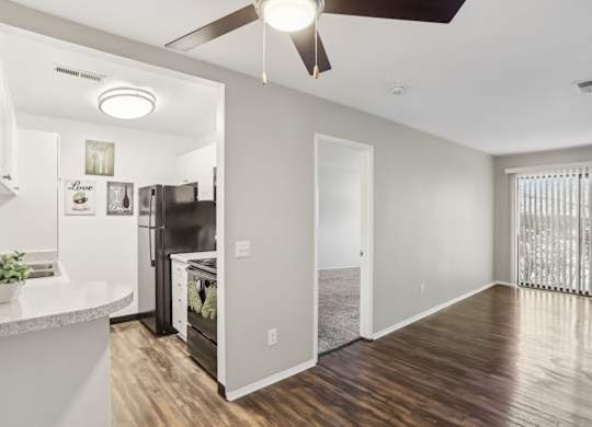 A modern kitchen with a refrigerator, oven, and a ceiling fan.at Creve Coeur, Creve Coeur, 63141