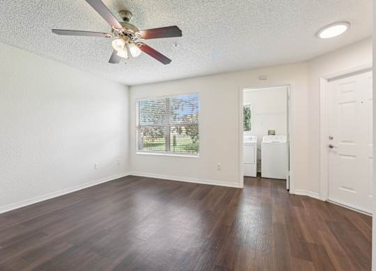 A room with a ceiling fan and a washing machine in it.