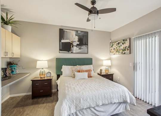 A bedroom with a large bed and a ceiling fan at Sweetwater At Metro North Apartments, Phoenix, AZ