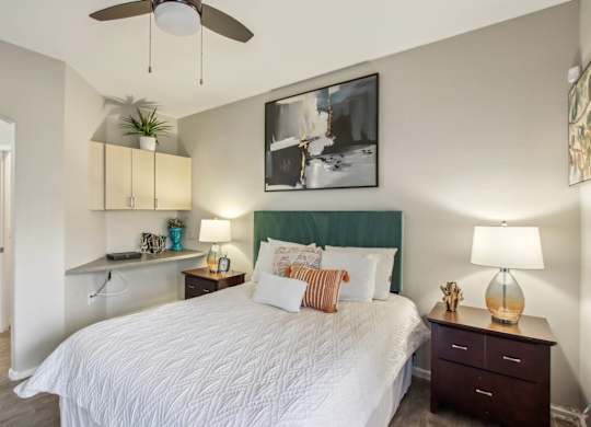 A bedroom with a large bed and a ceiling fan at Sweetwater At Metro North Apartments, Phoenix