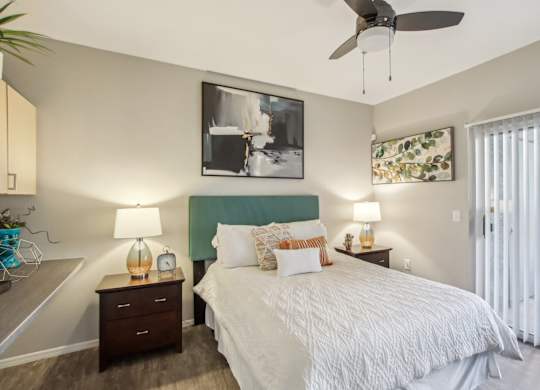 A bedroom with a bed, nightstands, and a ceiling fan at Sweetwater At Metro North Apartments, Phoenix, Arizona