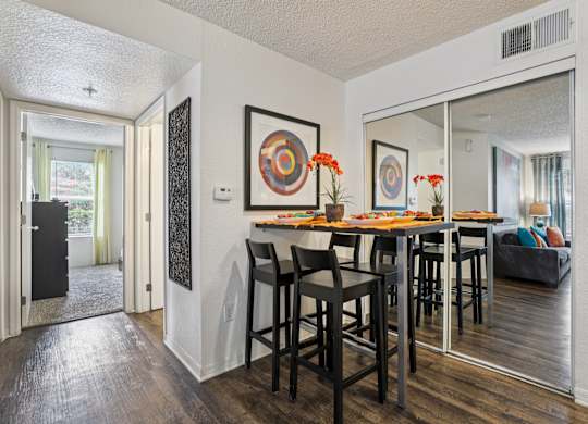 A dining room with a wooden table and chairs.