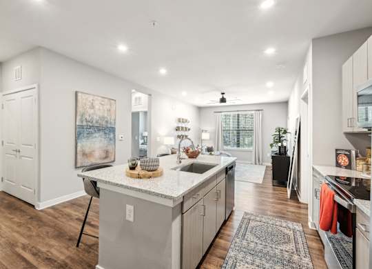 A modern kitchen with a large island and a dining area.