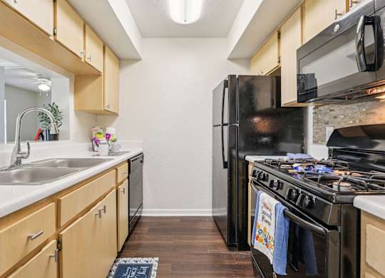 A kitchen with a black refrigerator and stove.