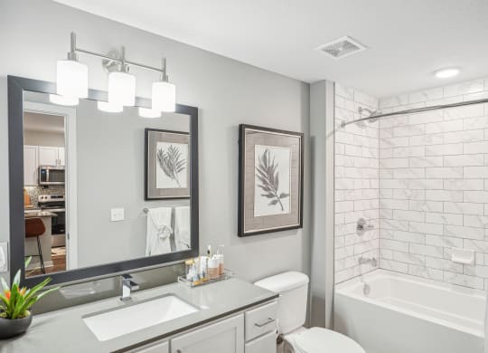 a white bathroom with a shower and a sink and a mirror at Edge75, Naples, Florida 34104
