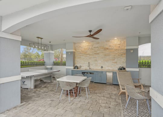 a patio with a dining area and a kitchen with a table and chairs at Edge75, Naples, Florida 34104