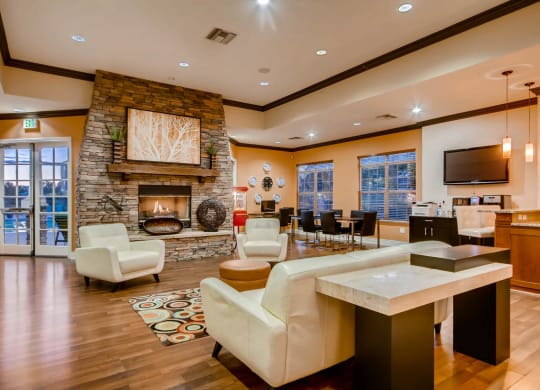 a large living room with a fireplace and a table at Heritage at Stone Mountain, Northglenn, CO, 80233