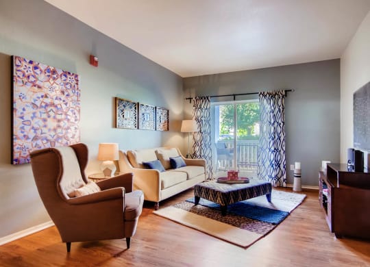 a living room with a couch and chairs and a table at Heritage at Stone Mountain, Northglenn, CO, 80233