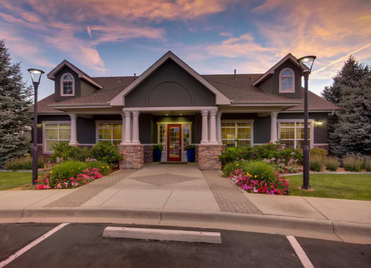 the front of a house with a driveway and a sunset at Heritage at Stone Mountain, Northglenn, CO, 80233
