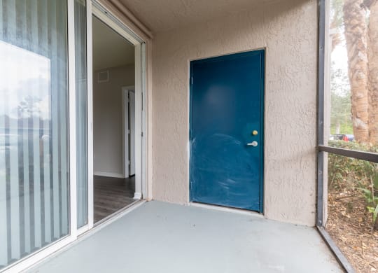 a porch with a blue door at the whispering winds apartments in pearland, tx at Heritage Bay, Jensen Beach, 34957