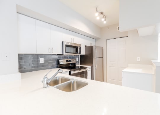 a kitchen with white countertops and stainless steel appliances at Heritage Bay, Florida, 34957