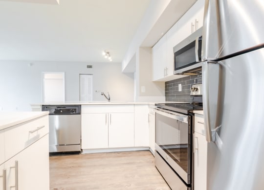 a kitchen with white cabinets and stainless steel appliances at Heritage Bay, Florida, 34957