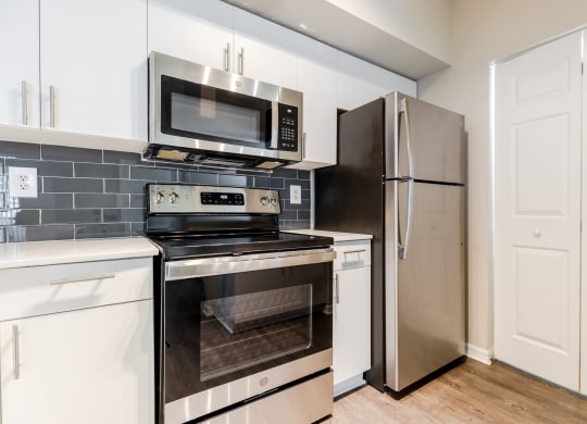 a kitchen with white cabinets and stainless steel appliances at Heritage Bay, Jensen Beach, FL