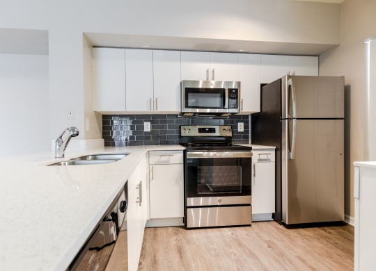 a kitchen with white cabinets and stainless steel appliances at Heritage Bay, Jensen Beach, 34957