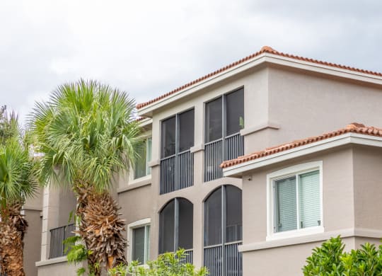 a condo building with a palm tree in front of it at Heritage Bay, Jensen Beach, 34957