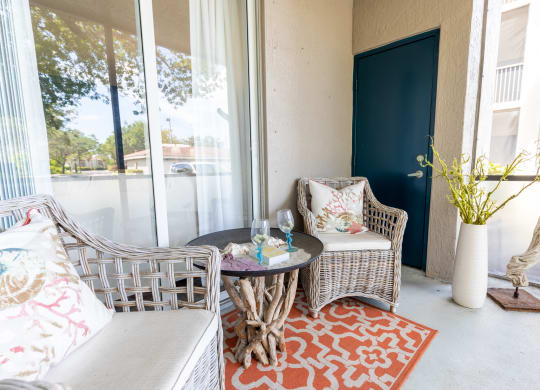 a patio with two chairs and a table at Heritage Bay, Jensen Beach, FL