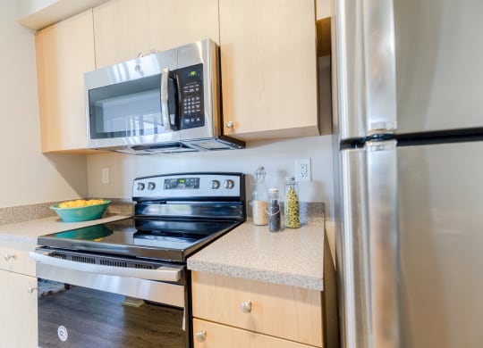 a kitchen with wooden cabinets and stainless steel appliances at Heritage Bay, Jensen Beach, 34957