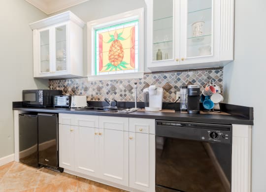 a kitchen with white cabinets and a black counter top at Heritage Bay, Jensen Beach, FL 34957