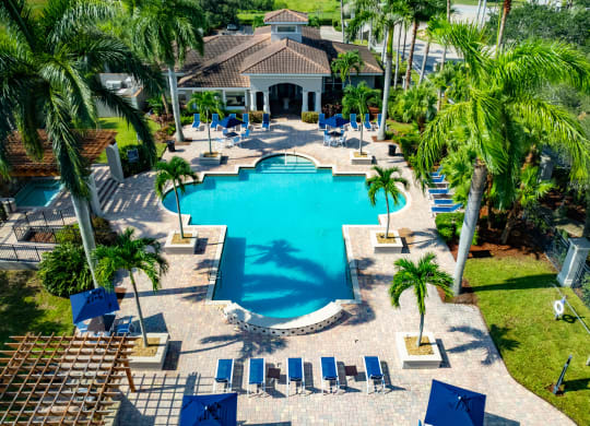 a large swimming pool with a house in the background at Heritage Bay, Jensen Beach, FL 34957