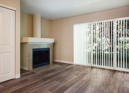A living room with a fireplace and a large window at Arcadia Townhomes, Federal Way, WA