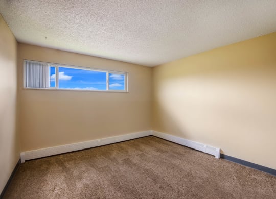 a bedroom with beige walls and a window at Broadmoor Springs, Colorado Springs, CO, 80906