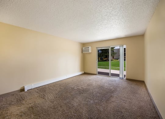 an empty room with a glass door leading to a yard at Broadmoor Springs, Colorado Springs, CO, 80906