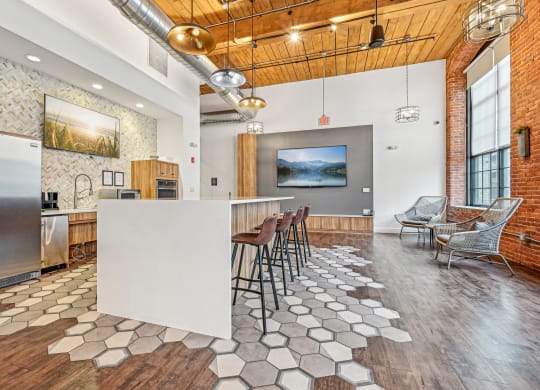 a kitchen with a white island and bar stools at Riverwalk Apartments, Lawrence, MA