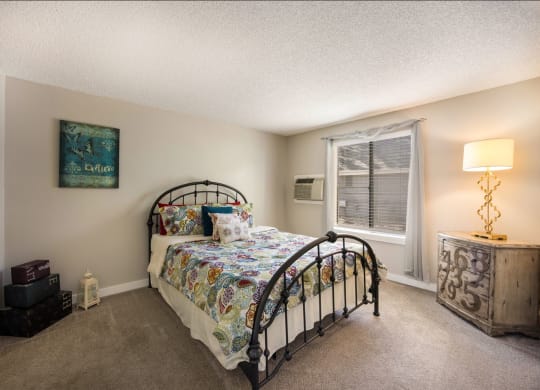 Bedroom with a bed and a window at Windmill Apartments, Colorado, 80916