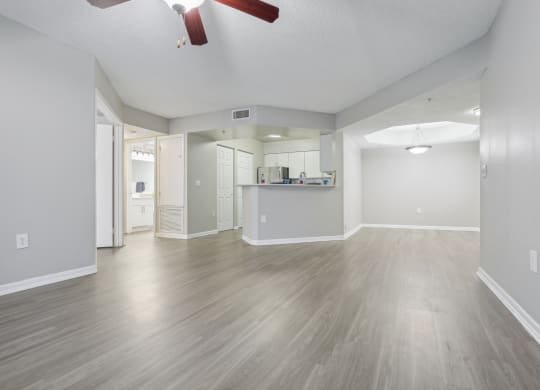 the living room and kitchen of an empty house with wood floors and a ceiling fan at Pembroke Pines Landings, Florida, 33025