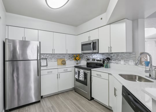 a kitchen with white cabinets and stainless steel appliances at Pembroke Pines Landings, Pembroke Pines, Florida
