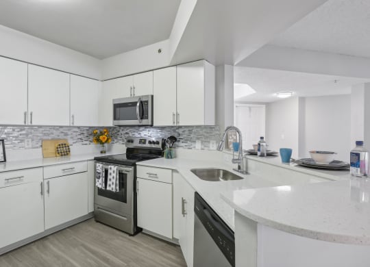 a kitchen with white cabinets and stainless steel appliances at Pembroke Pines Landings, Pembroke Pines