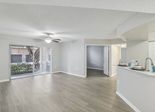 an open living room and kitchen with a sliding glass door to a patio at Pembroke Pines Landings, Pembroke Pines, Florida, 33025