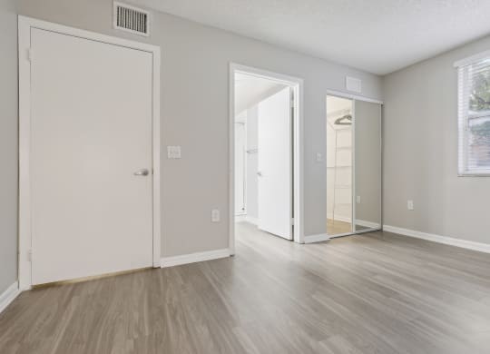 the living room of an apartment with white walls and wood floors at Pembroke Pines Landings, Pembroke Pines, FL 33025