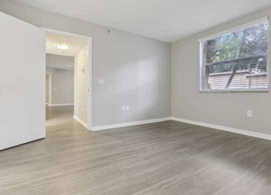 an empty living room with a large window and wood flooring at Pembroke Pines Landings, Pembroke Pines, FL 33025