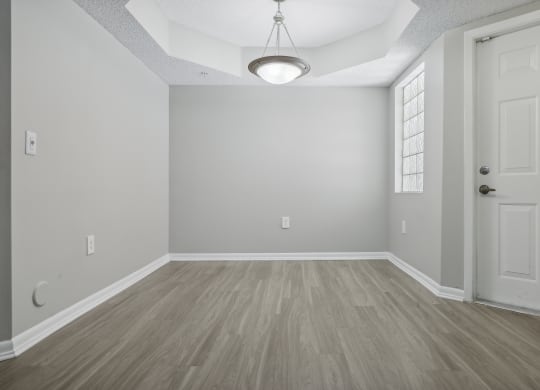 an empty living room with a white door and wood flooring at Pembroke Pines Landings, Florida, 33025