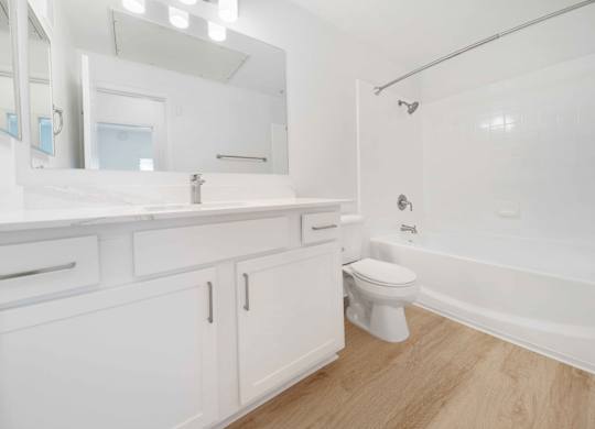 A white bathroom with a toilet, sink, and bathtub.
