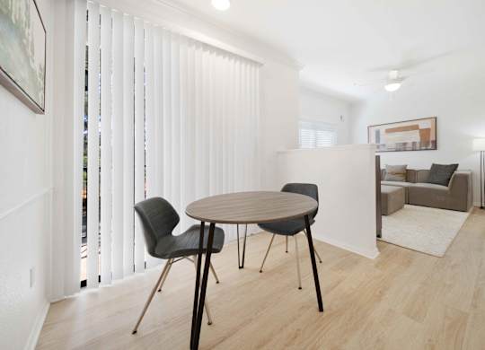 A dining room with a table and chairs.
