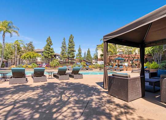 A poolside area with lounge chairs and a canopy.