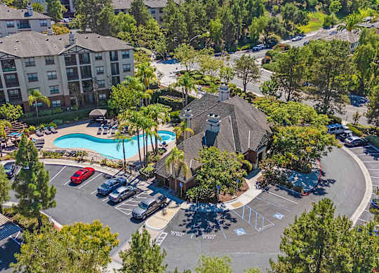 A large apartment complex with a pool and a parking lot.