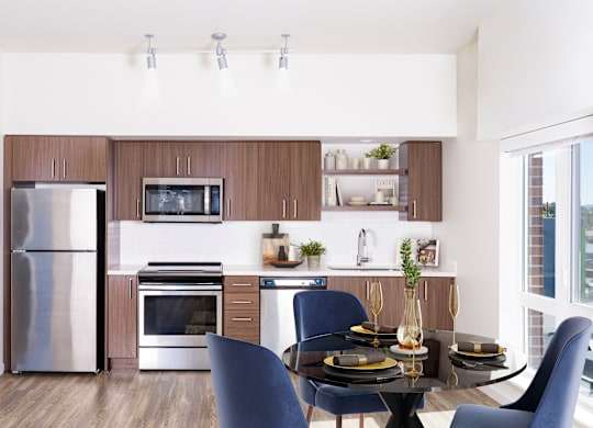 A modern kitchen with a dining table set for two.