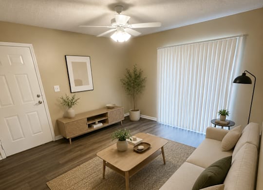 A living room with a couch, coffee table, and a ceiling fan.