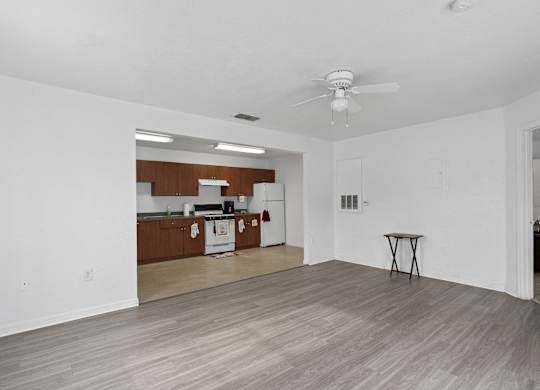 living room with a ceiling fan and a kitchen at The Groves at Wimauma Apartments , Wimauma, 33598
