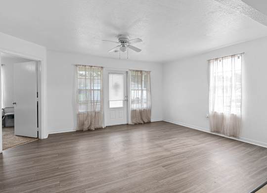 the living room of an empty house with a ceiling fan at The Groves at Wimauma Apartments , Wimauma