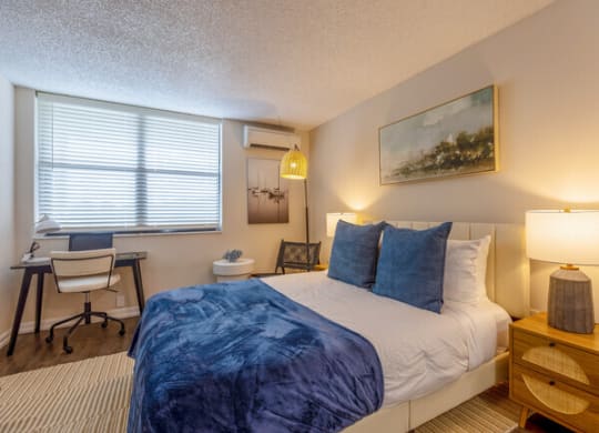 a bedroom with a bed and a desk with a chair  at Club at Emerald Waters, Hollywood, 33021
