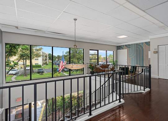 a lobby with a view of a yard and a table and chairs  at Cypress Grove, Lauderhill, 33313