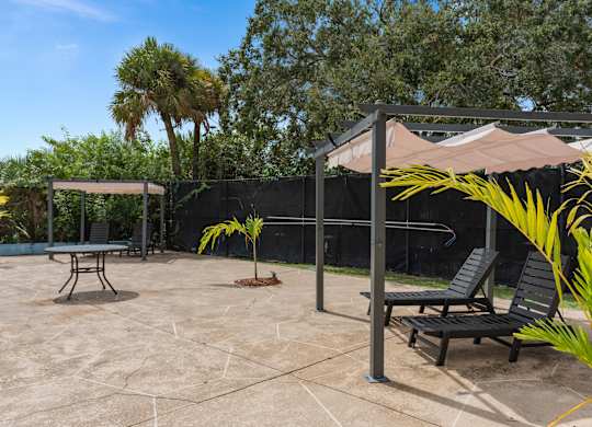 a patio with two chairs and a canopy at Cypress Grove, Lauderhill, FL