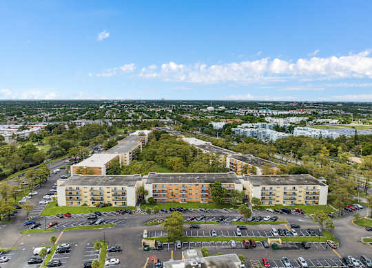 an aerial view of an apartment complex with a parking lot and trees at Cypress Grove, Lauderhill, FL