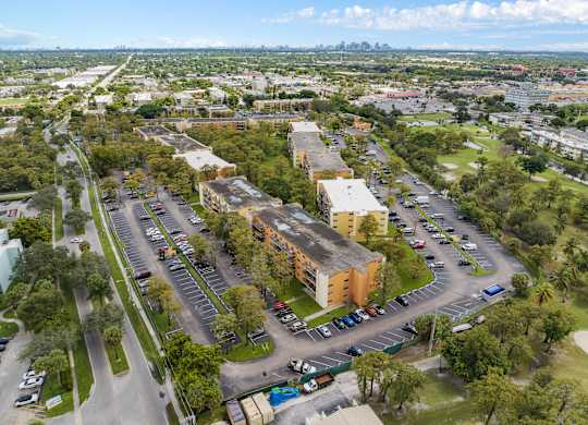 an aerial view of an empty parking lot with buildings and trees at Cypress Grove, Lauderhill, FL, 33313