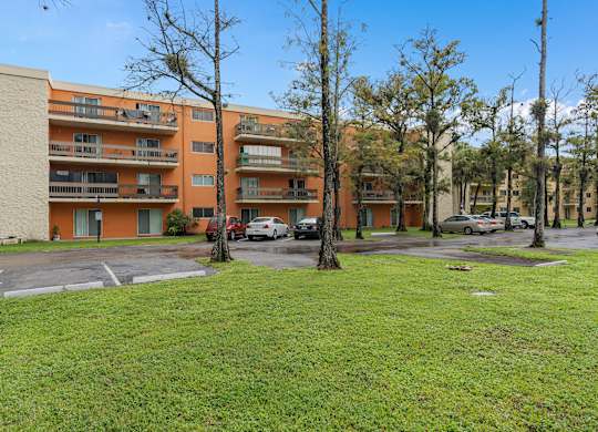 the view of an apartment building with cars parked in a parking lot at Cypress Grove, Lauderhill, 33313